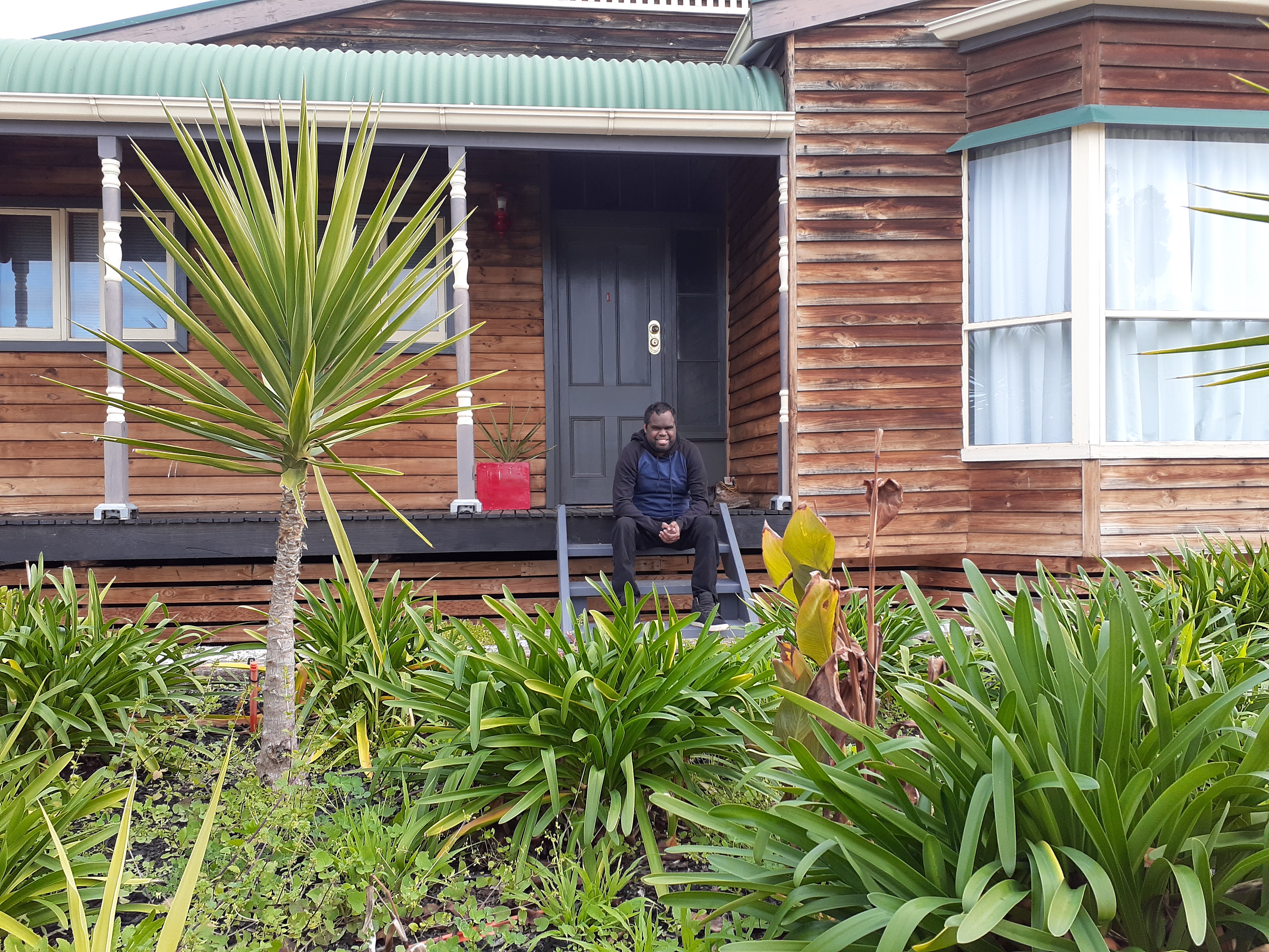 Norman sitting on the steps of his front porch.